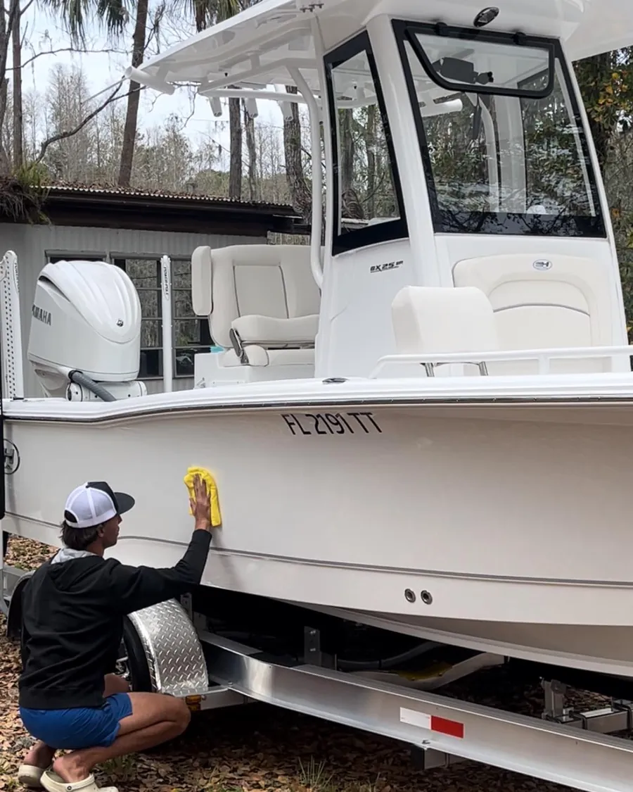Sunrise Marine crew member hand detailing a customer boat at the dock